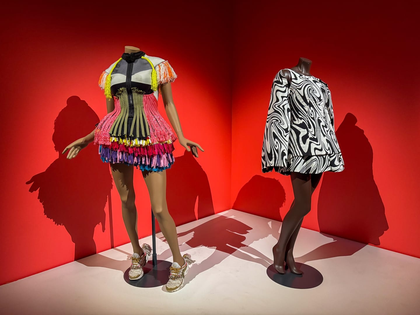 Side view of two bold dresses from the Africa Fashion showcase, highlighting vibrant textures and experimental silhouettes.